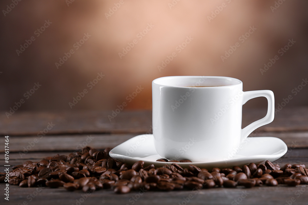 Cup of coffee and beans on blurred background Cup of coffee and beans on blurred background