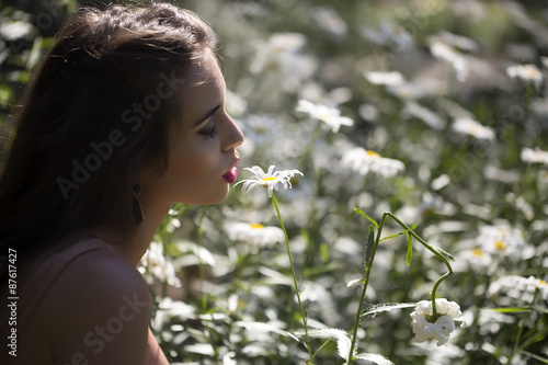 Beautiful girl and field of daisies