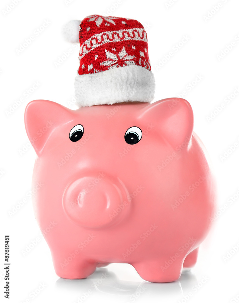 Piggy bank with Santa hats isolated on white Piggy bank with Santa hats isolated on white