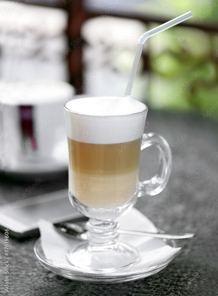 Glass of latte on table in cafe close-up Glass of latte on table in cafe close-up