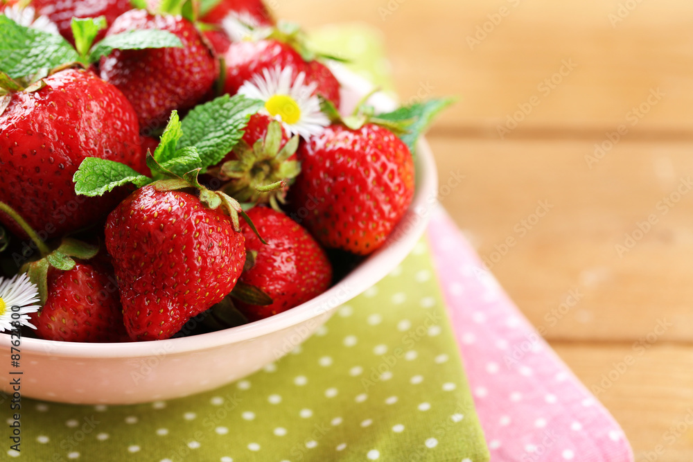 Red ripe strawberries in bowl, on color wooden background Red ripe strawberries in bowl, on color wooden background
