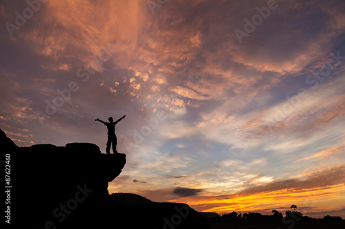 Silhouette of a man on the rock at sunset