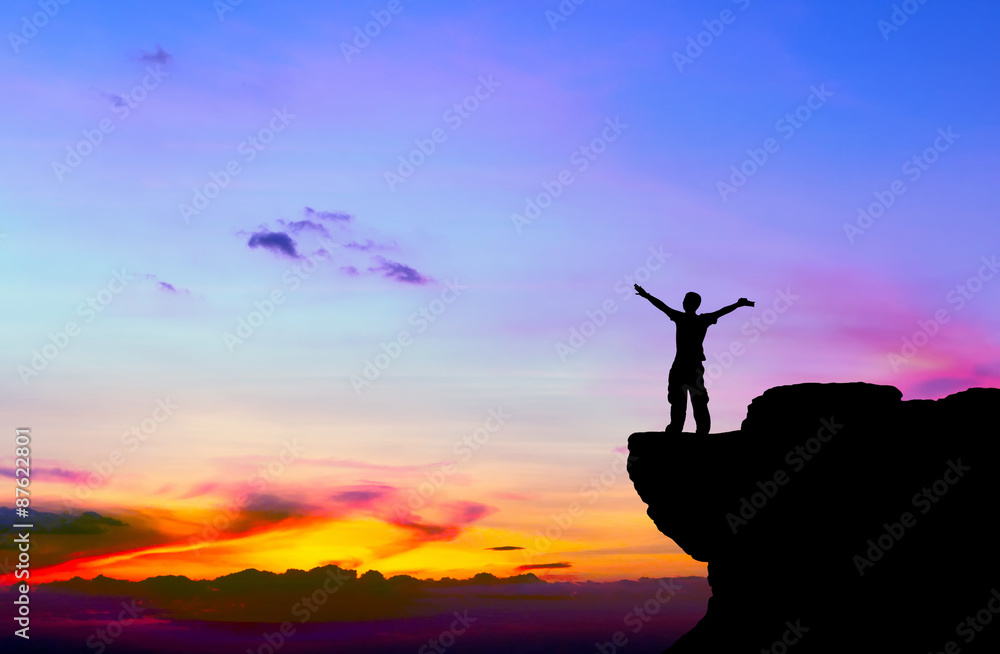 Silhouette of a man on the rock at sunset