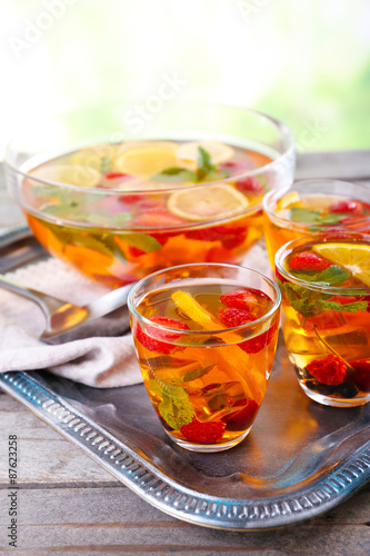 Fruity punch in glassware on metal tray, closeup