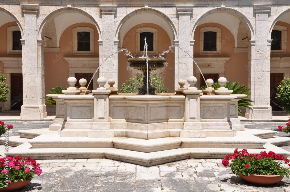 Stone fontana against the building with arcades in the Monastery of Monte Cassino