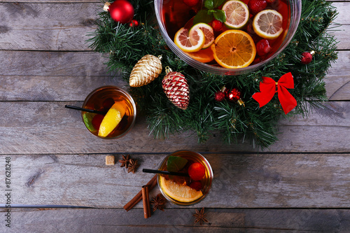 Sangria in bowl and glasses with Christmas decoration on wooden table close up