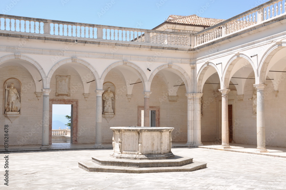 Obraz premium Courtyard Benedictine Monastery at Monte Cassino, a stone fountain and arcades