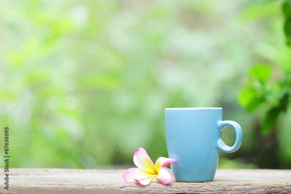 blue mug and plumaria flower on wood table blue mug and plumaria flower on wood table