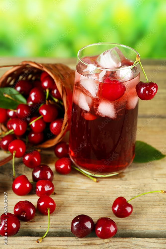 Glass of fresh juice with cherries on wooden table close up Glass of fresh juice with cherries on wooden table close up