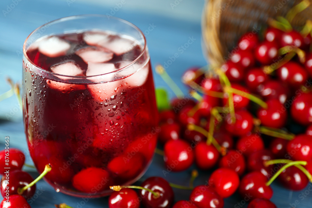 Glass of fresh juice with cherries on wooden table close up Glass of fresh juice with cherries on wooden table close up