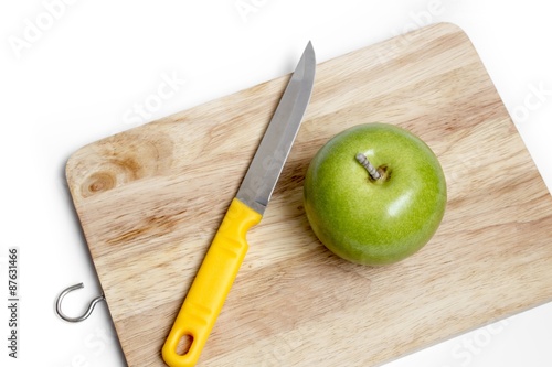 knife and Green apple with block wood on white background