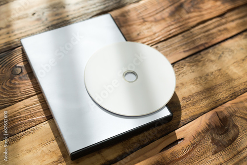 Blank compact disc with cover on wood background ground photo