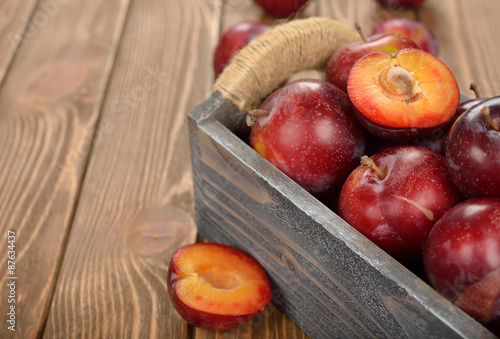 Fresh plums in a wooden box