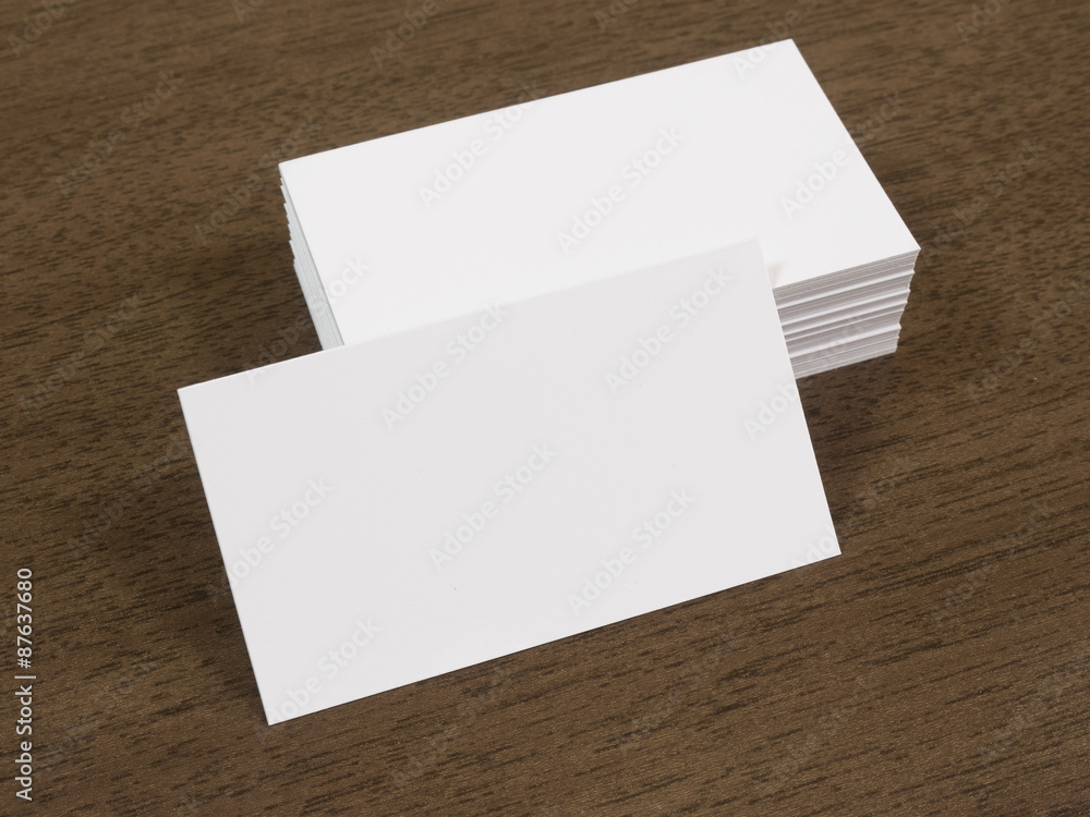 Pile of business cards on a wooden desk Pile of business cards on a wooden desk