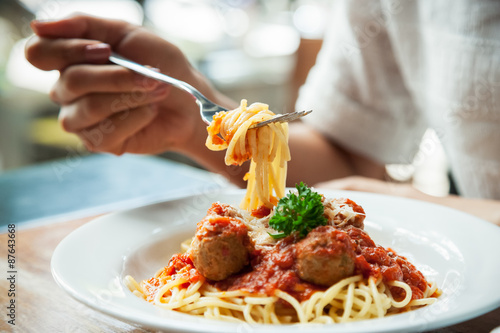 close up of woman eating spaghetti with fork