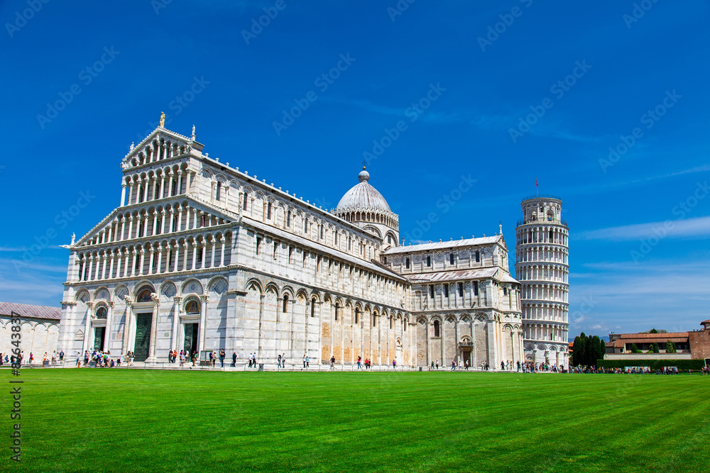 PISA, ITALY - MAY 10, 2014: Tourists on Square of Miracles visiting Leaning Tower in Pisa, Italy. Leaning Tower of Pisa is campanile and is one of the most famous buildings in the world