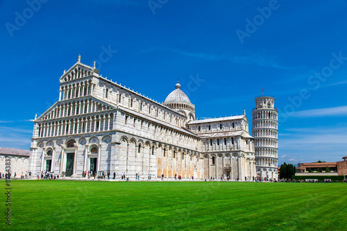 PISA, ITALY - MAY 10, 2014: Tourists on Square of Miracles visiting Leaning Tower in Pisa, Italy. Leaning Tower of Pisa is campanile and is one of the most famous buildings in the world