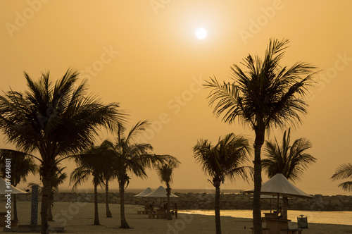 Almost empty beach, palm trees and orange sunset © VeronikaSmirnaya