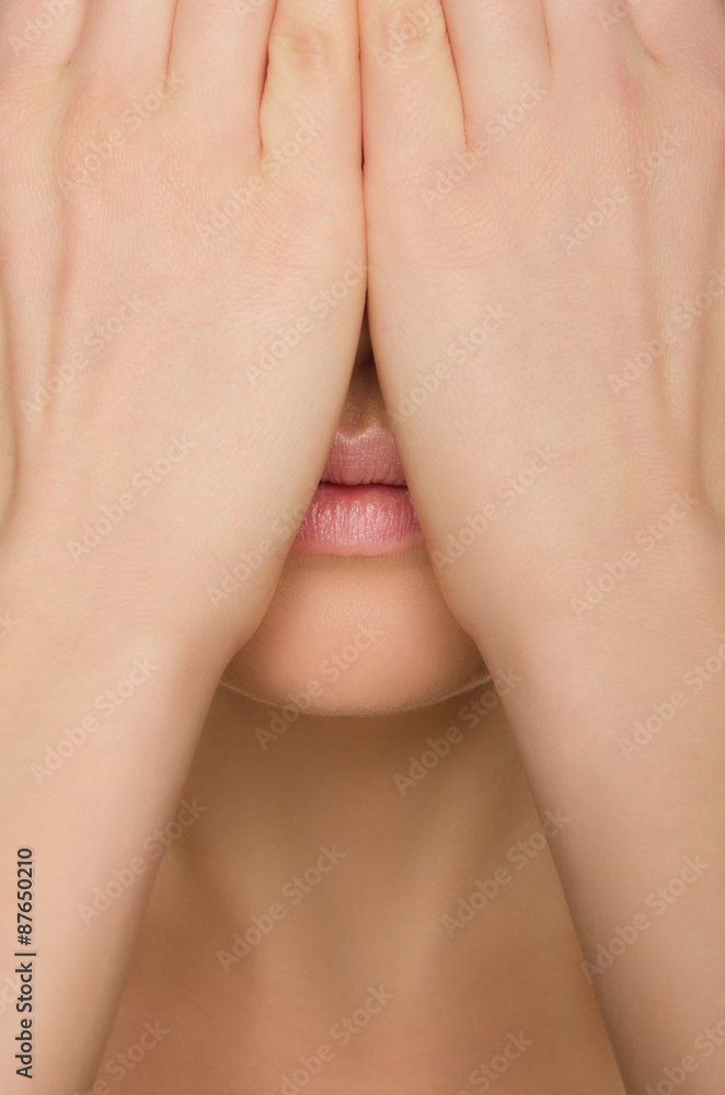 Fototapeta premium woman's face covered by two hands