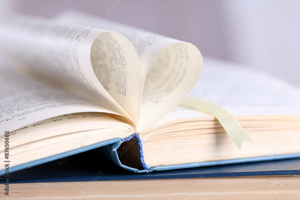 Obraz premium Pages of book curved into heart shape, close up