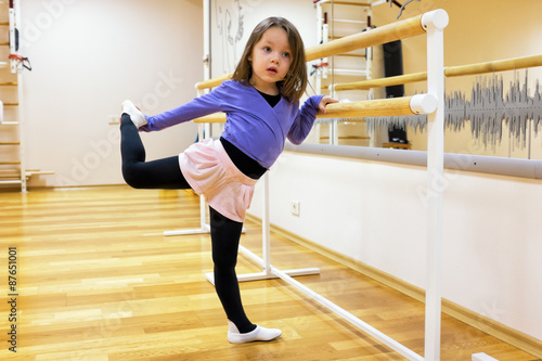 Child, a girl is engaged in ballet, gymnastics, yoga in the gym