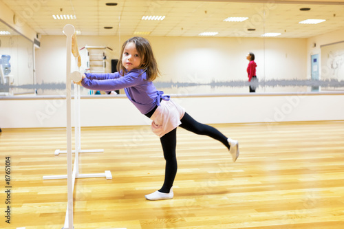 Child, a girl is engaged in ballet, gymnastics, yoga in the gym
