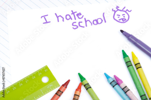 School Supplies and I Hate School – A child has written I Hate School with a marker. Crayons, ruler, and notebook paper in the background.