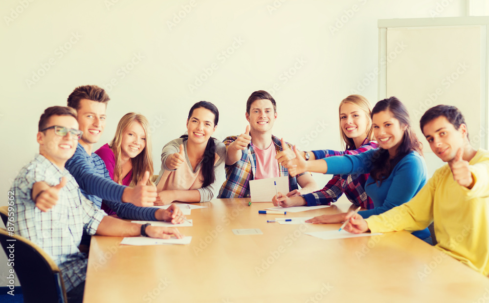 group of smiling students with hand on top group of smiling students with hand on top