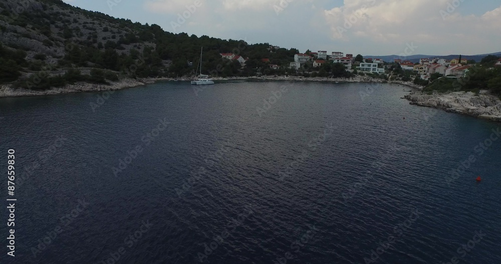 Escena aérea con dron de bahía croata, catamarán anclado. Cámara viaja rápidamente a través de la bahía hasta el velero, catamarán. Costa dálmata. Croacia. Escena aérea con dron de bahía croata, catamarán anclado. Cámara viaja rápidamente a través de la bahía hasta el velero, catamarán. Costa dálmata. Croacia.
