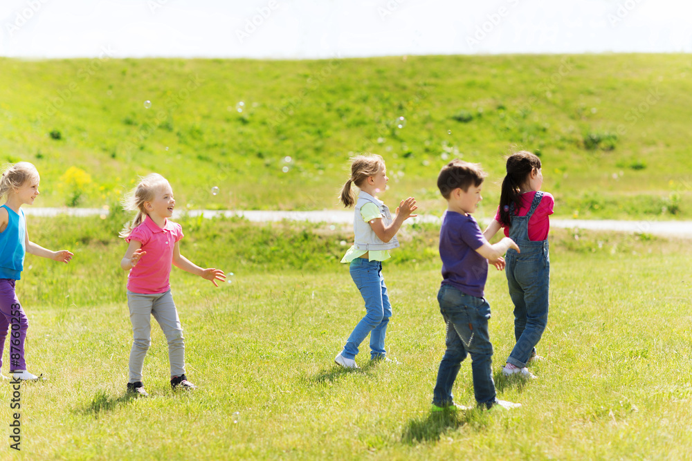 group of kids catching soap bubbles outdoors group of kids catching soap bubbles outdoors