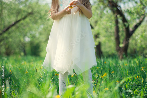 Little girl in white dress holding a flower