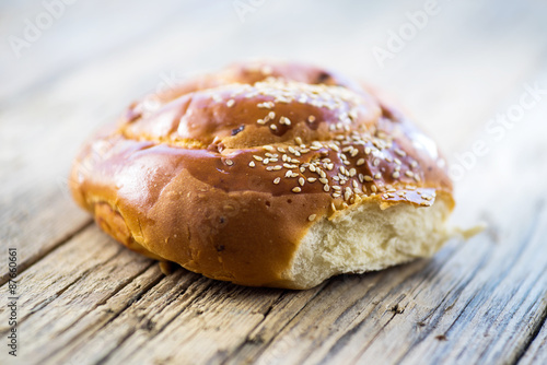 sandwich bun with sesame seeds on wooden background