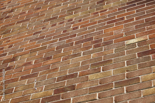 Close up of a high, red brick house wall at angle in perspective