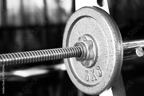 Barbell focused on 5 kg plate black and white