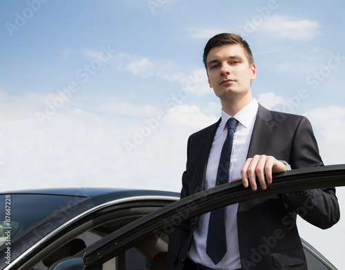 Young businessman near car