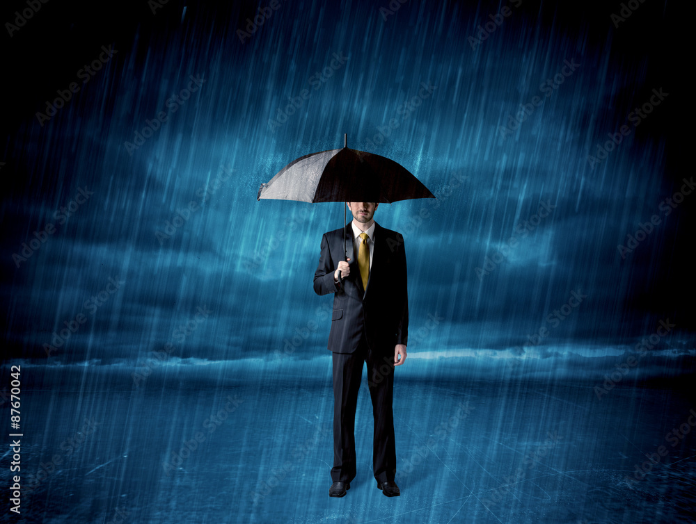 Business man standing in rain with an umbrella Business man standing in rain with an umbrella
