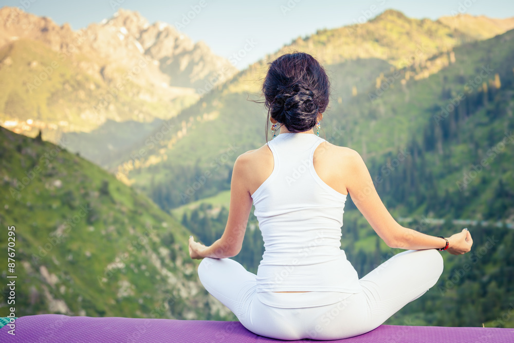 Beautiful woman relaxing and meditating outdoor at mountain