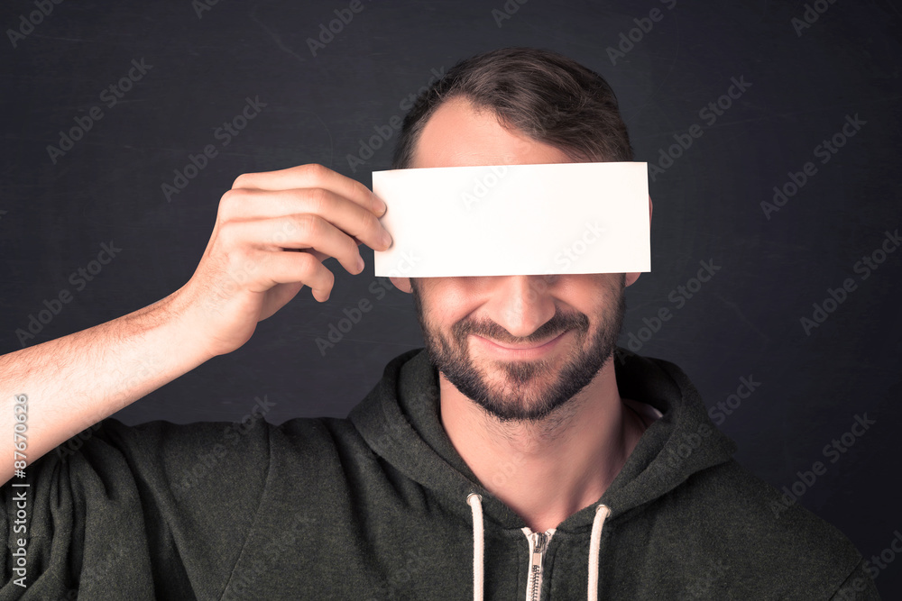 Handsome man holding copy space paper at his eye Handsome man holding copy space paper at his eye