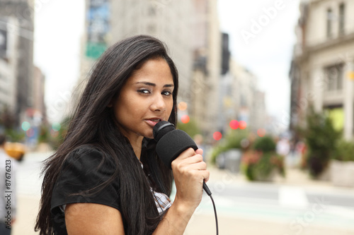 Принти на полотні A female newscaster talking into her microphone.