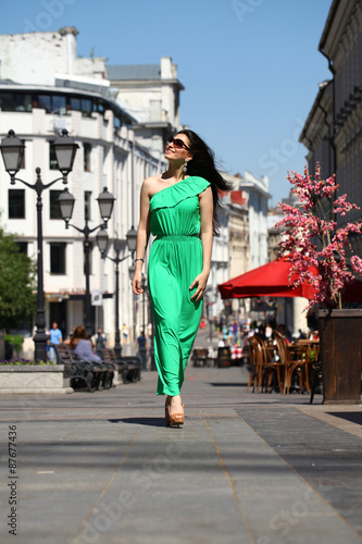 Beautiful young brunette woman in green long dress