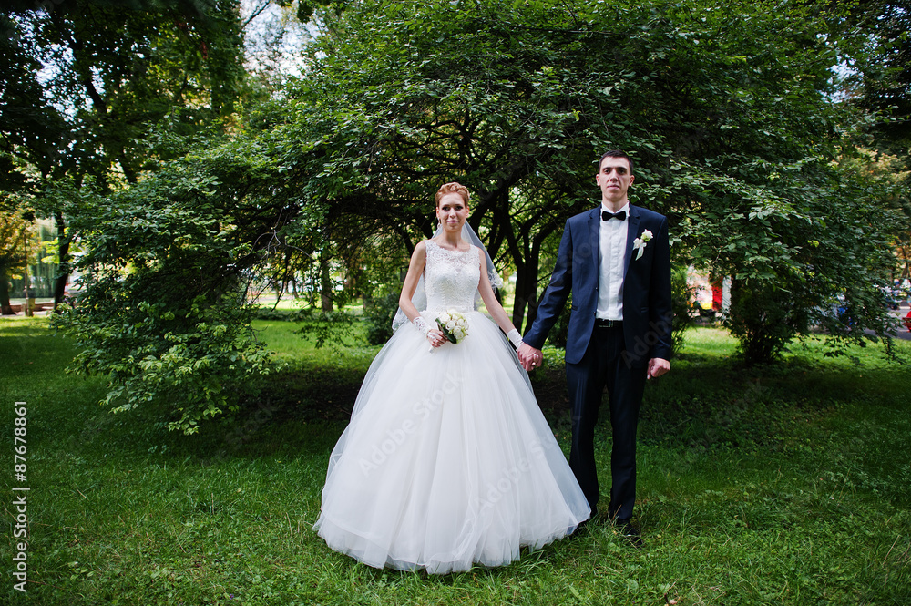 exciting elegant wedding couple walking at park in love