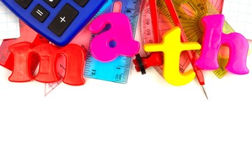 Toy magnetic letters spelling math with a math-themed school supplies top border over white