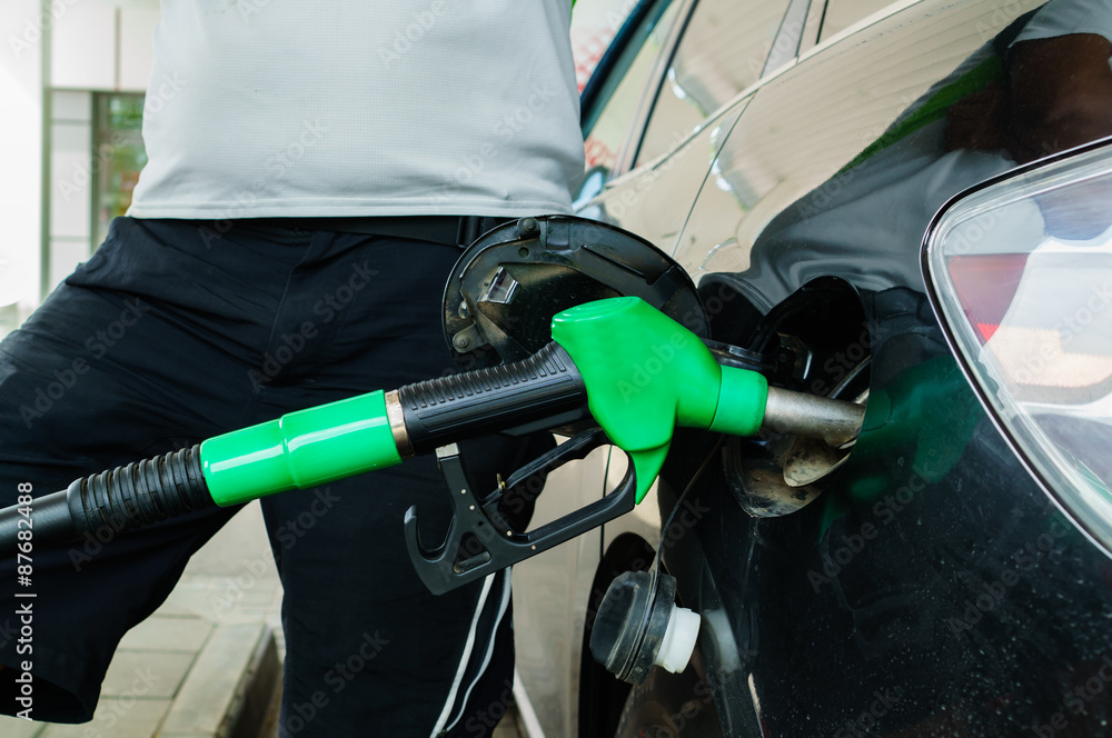 Man fills up his car with a gasoline at gas station Man fills up his car with a gasoline at gas station
