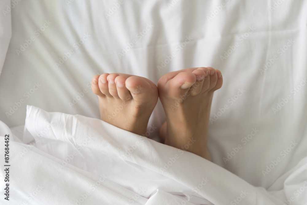 Two feet in a bed against a white background Two feet in a bed against a white background