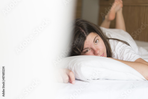 young woman sleeping on the white linen in bed at home,