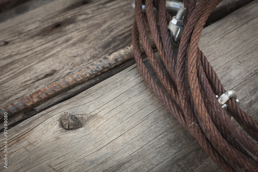 Obraz premium Abstract Rusty Iron Cable Laying on Old Wood Planks