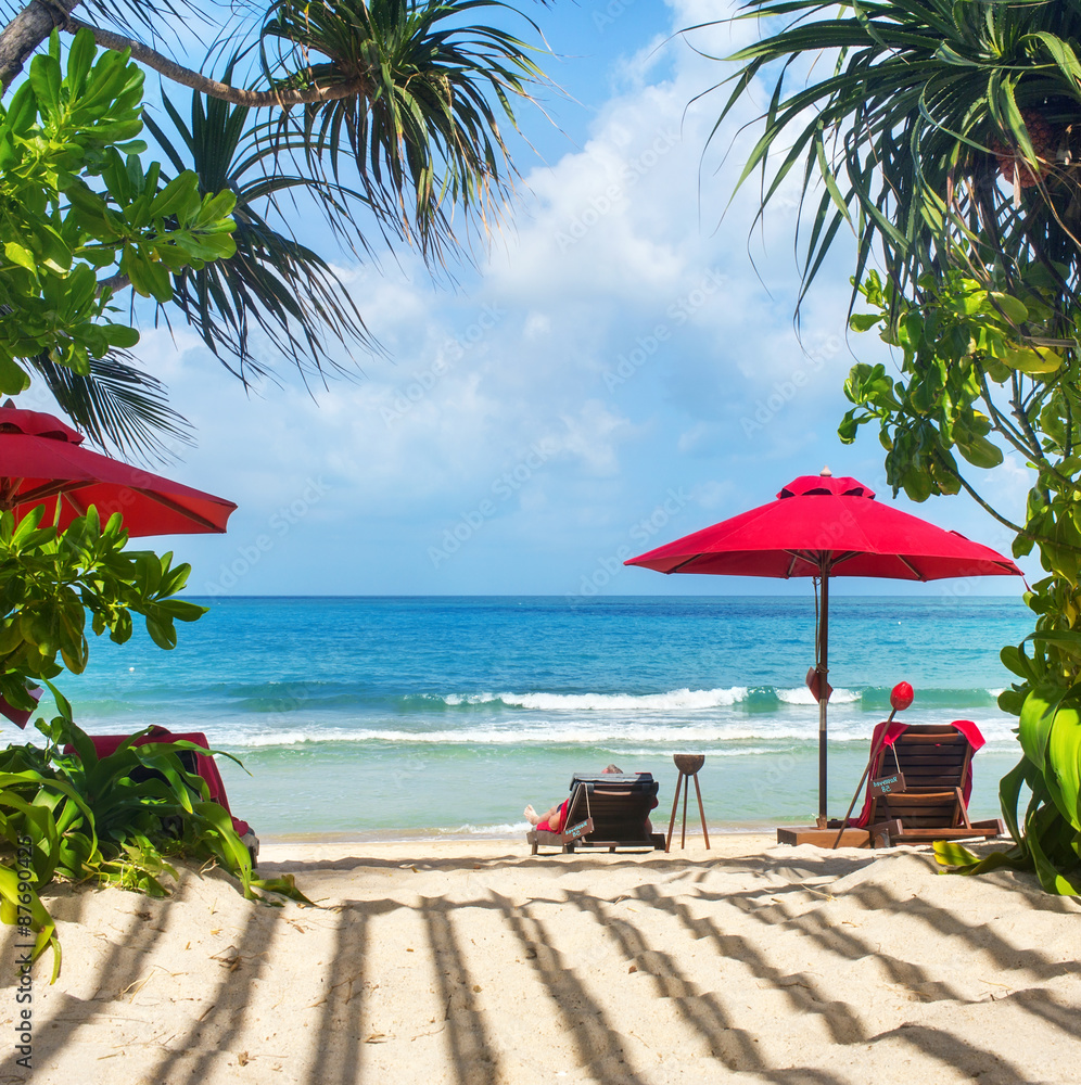 beach vacation. Photo of sun loungers under the red sun umbrella
