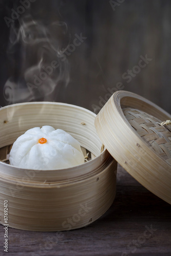 Chinese steamed bun in bamboo ware on wooden table