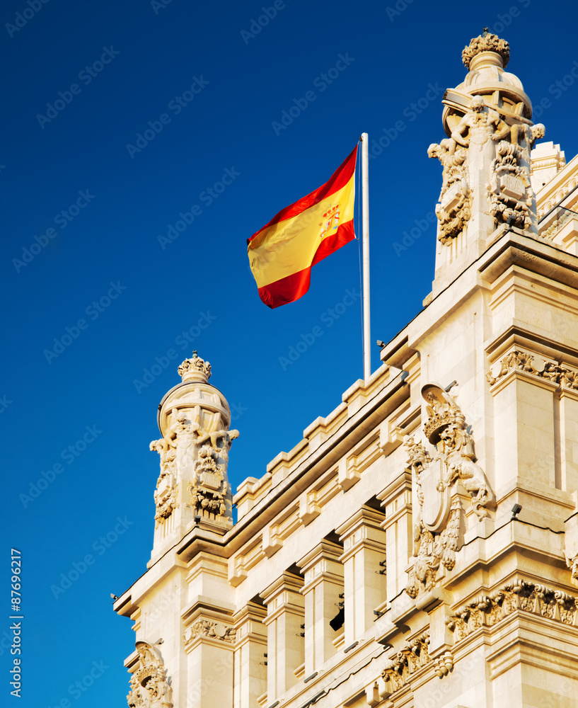 The flag of Spain fluttering on the Cybele Palace in Madrid