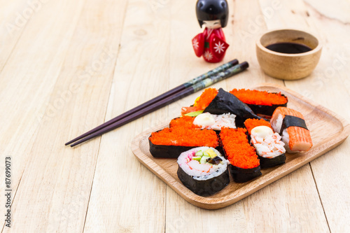 Japanese sushi traditional food on wooden plate with kokeshi.